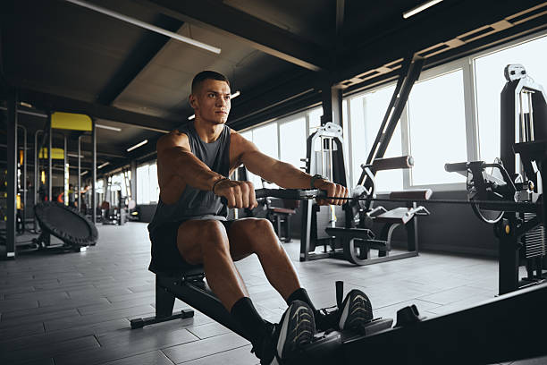 istock Handsome fit male practicing on rowing machine in modern gym 2214550960