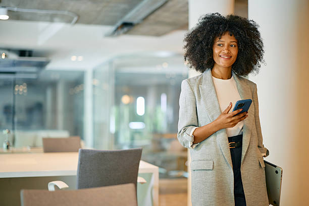istock Smiling businesswoman using smartphone in modern office 2214551318