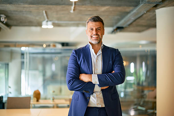 istock Confident businessman smiling with arms crossed in modern office 2214551320