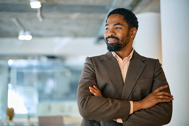 istock Confident businessman standing with arms crossed in modern office 2214551361