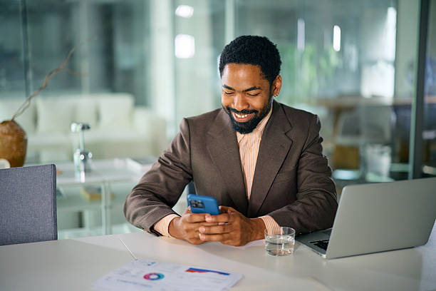 istock Smiling businessman using smartphone in modern office 2214551494