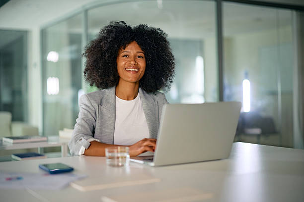 istock Smiling businesswoman working on laptop in modern office 2214551521