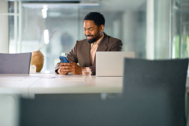 istock Smiling businessman using smartphone in modern office 2214551587