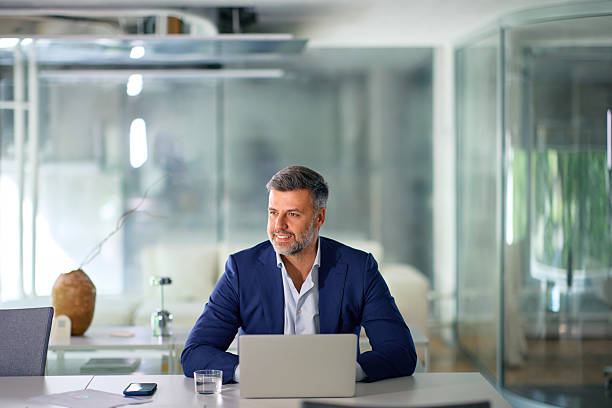 istock Confident businessman working on laptop in modern office 2214551639