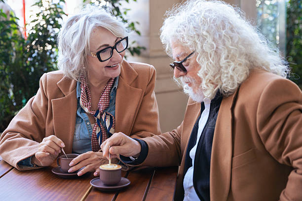 istock Caucasian senior couple talking closely while drinking coffee at outdoor cafe 2214553592
