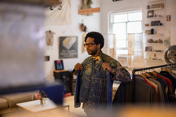 istock Man choosing a denim jacket in a vintage shop 2214554003
