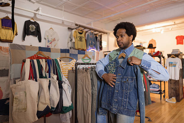 istock Stylish man choosing clothes in vintage second hand shop 2214554052