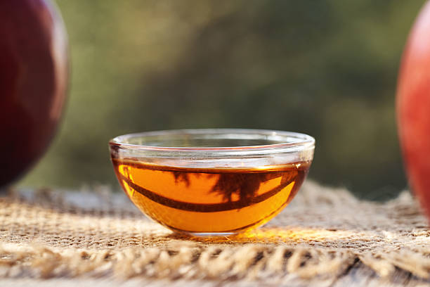 istock Apple cider vinegar in a glass bowl with fresh red apples 2214558376