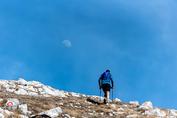 Rear view of a hiker with backpack in the volcanic nature of Stromboli island at sunset, Stromboli island, Aeolian islands, Tyrrhenian Sea, Sicily, South of Italy, Italy, Mediterranean Sea, Europe