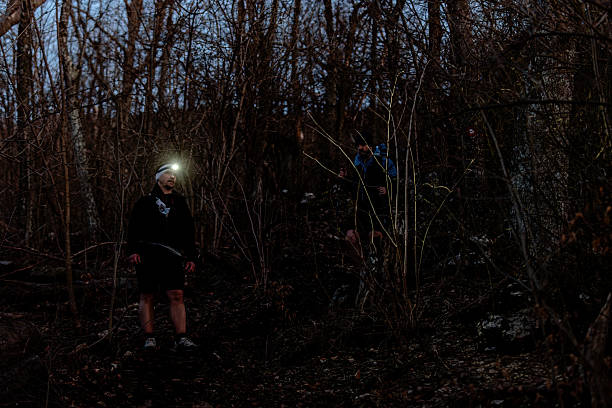 istock Hikers returning at night through dark forest with headlamps 2214559045
