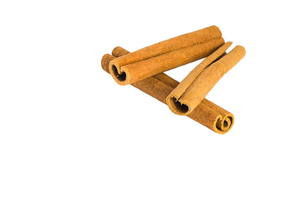 istock Cinnamon bark curls and chips spread across a white background, showcasing their aromatic appeal and texture. 2214559857