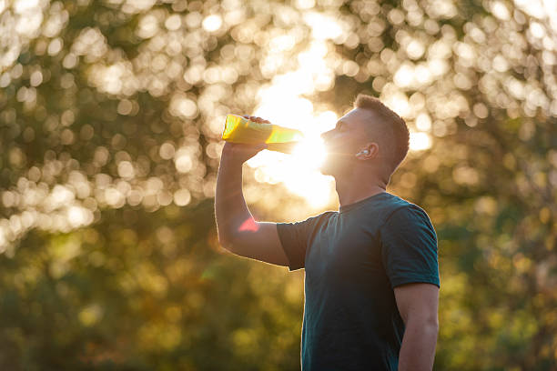 istock A fit young man drinking water from a bottle after a run or workout in a summer park, active healthy lifestyle. 2214570274