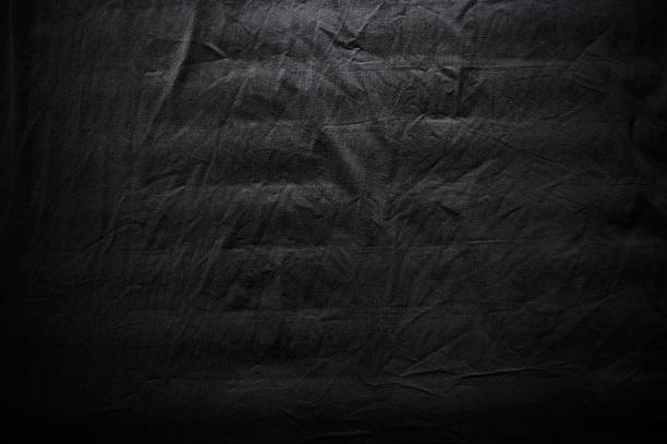 istock Texture of dark black crumpled and creased fabric material 2214572146