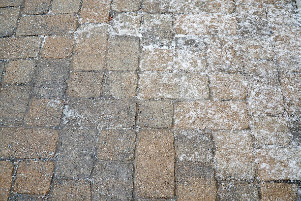 istock winter ice melting salt on the brick ground 2214574508