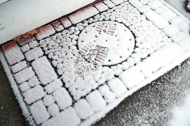 istock close up on doormat in front door after snow 2214574536