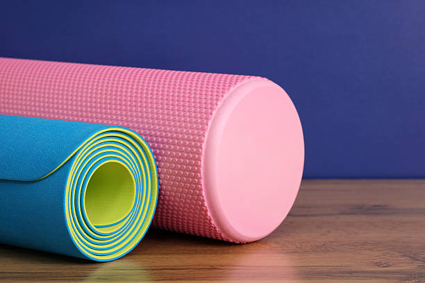 istock Sports background: pink foam roller and blue mat for training at home. 2214576509