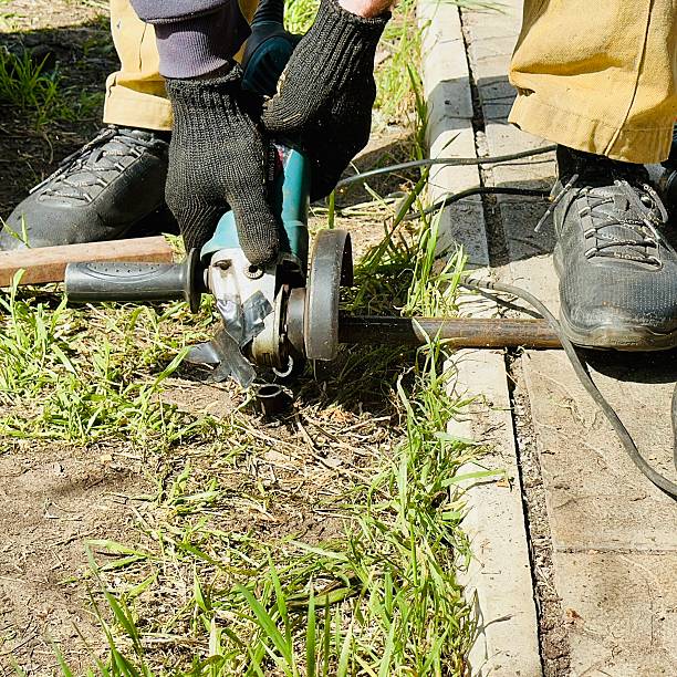 istock craftsman cutting metal with angle grinder outdoors 2214578964