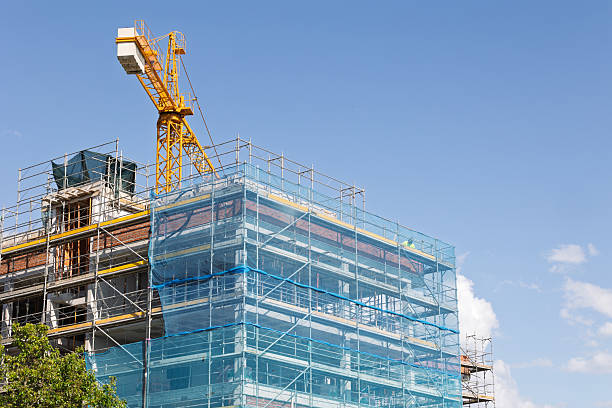 istock Building under construction with scaffolding and crane on a sunny day 2214579333