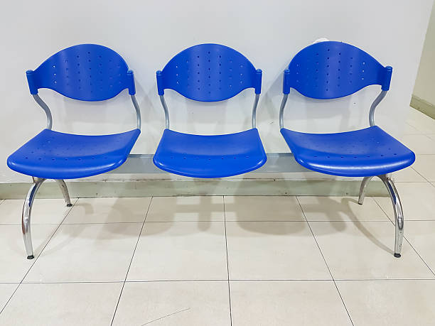 istock Row of Three Blue Plastic Waiting Chairs with Metal Frame on Tiled Floor 2214583284