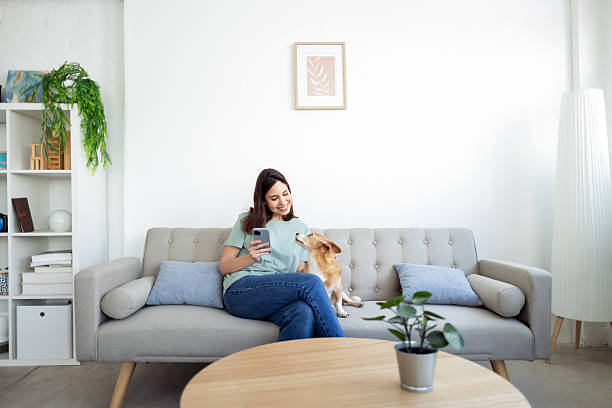 istock Young woman relaxing with her dog on a cozy sofa 2214583845