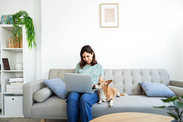istock Woman working from home with her dog on the sofa 2214583908