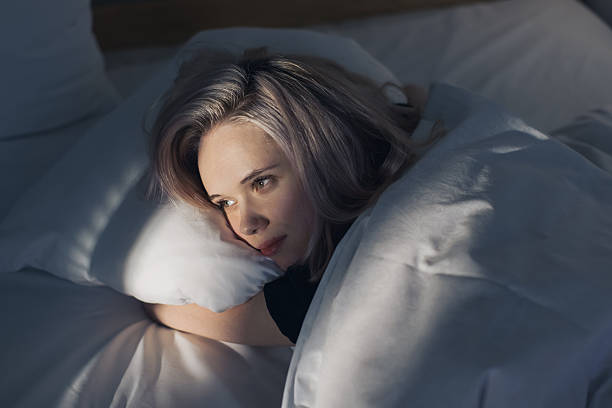 istock Young woman on bed 2214584054