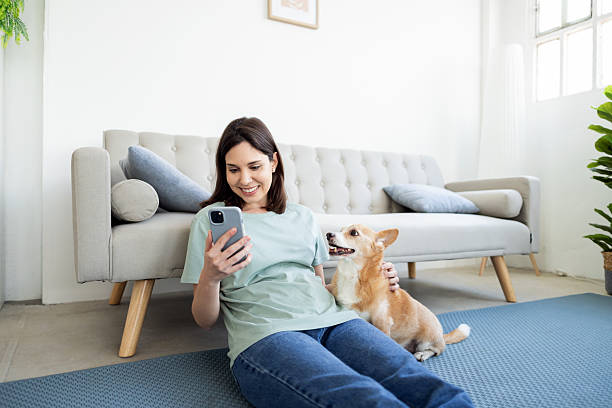 istock Woman relaxing with her dog while using smartphone 2214584089