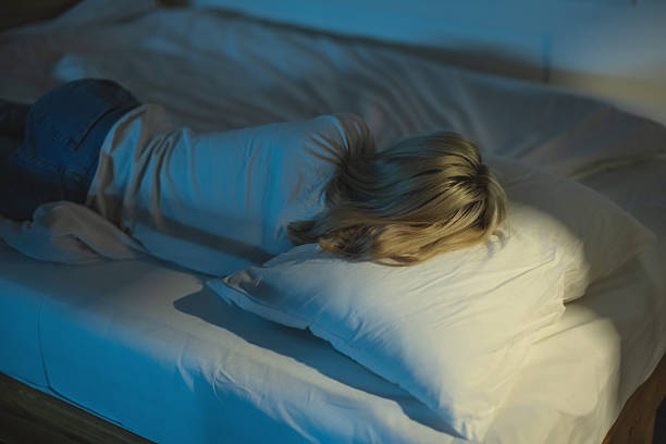 istock Young woman sleeping on bed 2214584108