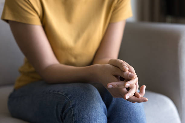 istock Young woman holding folded hands on lap 2214586842