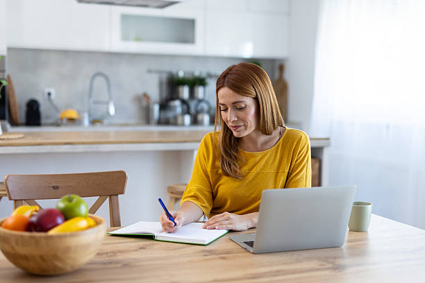 istock Thoughtful Woman Reviews Notes in Stylish Kitchen Setting 2214594591