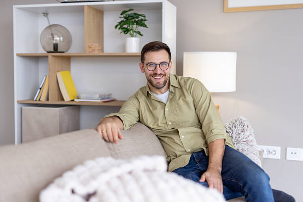 istock Man relaxing on a sofa with a friendly smile 2214594678