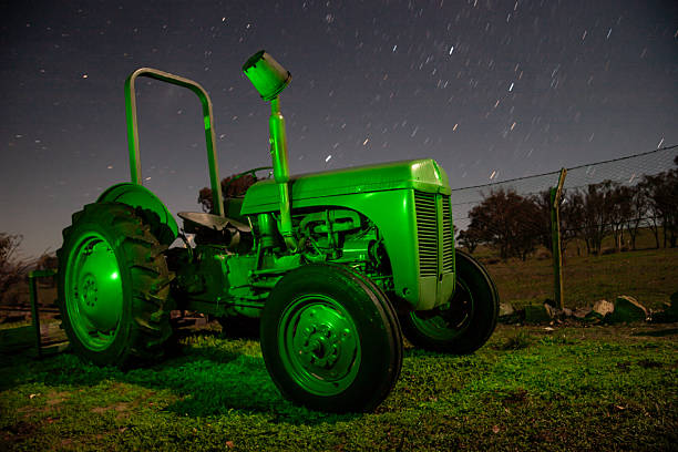 A classic grey Ferguson tractor positioned in a rural paddock beneath a canopy of stars.