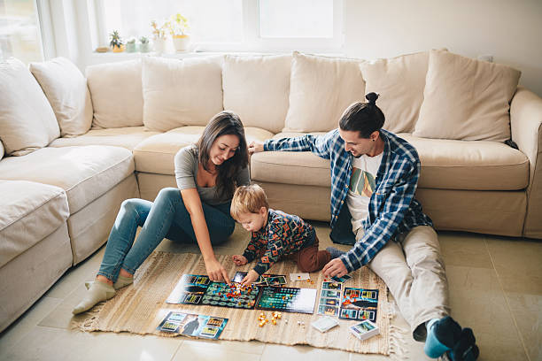 istock Young family showing their child a board game. 2214595553