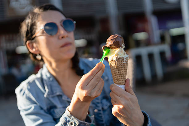 istock Woman tasting ice cream with little spoon in a waffle cone 2214596462