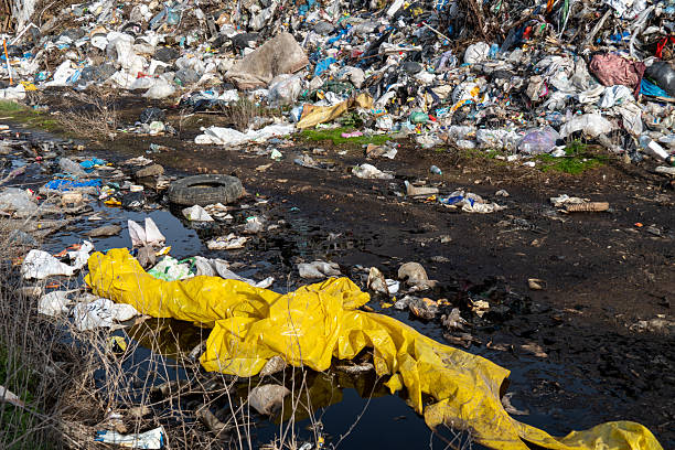 istock Large Landfill Polluting a Waterway, Overflowing with Discarded Plastics and Waste Materials, Causing Severe Environmental Damage 2214597009