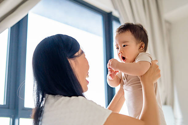 istock mother carrying her baby at home 2214597794