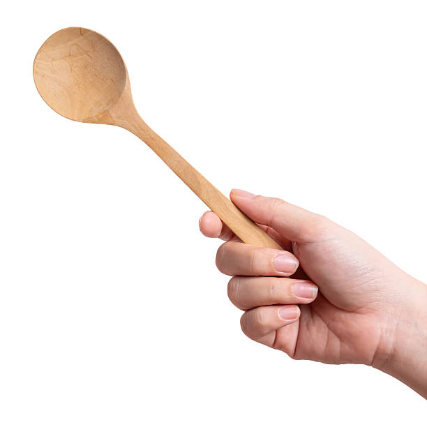 istock Female hand holding a wooden spoon isolated on white background. 2214599901