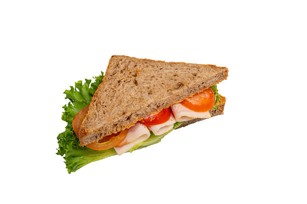istock A ham sandwich with lettuce, tomato, and ham on whole-wheat bread is isolated on a white background. 2214606629
