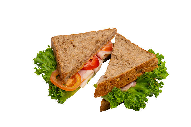 istock Two ham sandwiches with lettuce, tomato, and ham on whole-wheat bread are isolated on a white background. 2214606669