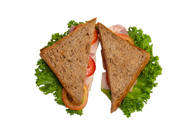 istock Two ham sandwiches with lettuce, tomato, and ham on whole-wheat bread are isolated on a white background. 2214606671