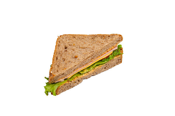 istock A ham sandwich with lettuce, tomato, and ham on whole-wheat bread is isolated on a white background. 2214606672