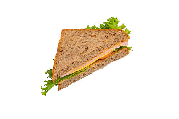 istock A ham sandwich with lettuce, tomato, and ham on whole-wheat bread is isolated on a white background. 2214606677