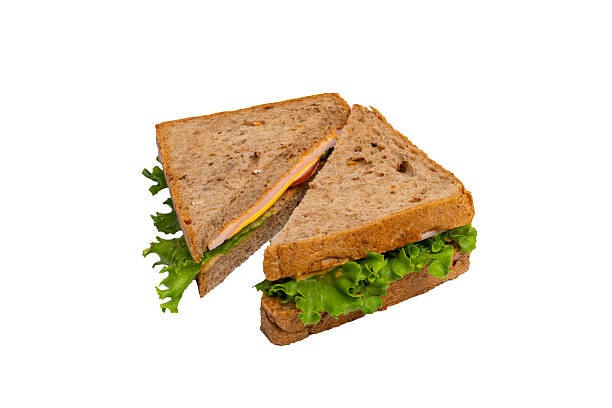 istock Two ham sandwiches with lettuce, tomato, and ham on whole-wheat bread are isolated on a white background. 2214606680