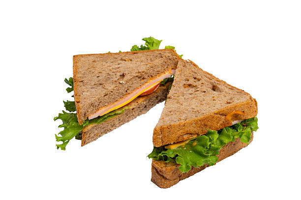 istock Two ham sandwiches with lettuce, tomato, and ham on whole-wheat bread are isolated on a white background. 2214606696