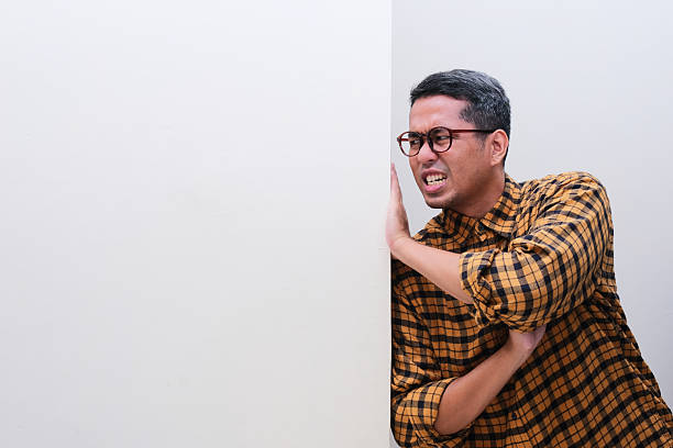 istock A man pushing a blank white wall with full of effort 2214607555