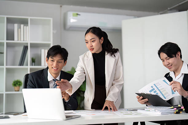 istock Team Engagement and Analysis. Professionals collaborating on business strategies using digital tools and charts. 2214610978