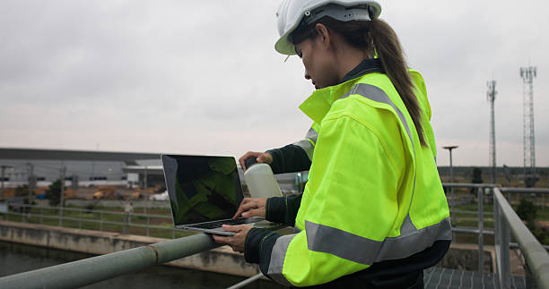 istock Two Industrial or Environment engineer hold sample wastwater discussing on laptop for Sewage treatment 2214614296