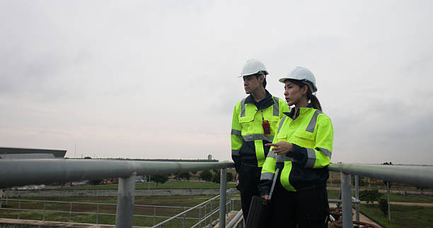 istock Two Industrial or Environment engineer hold sample wastwater discussing on laptop for Sewage treatment 2214614341