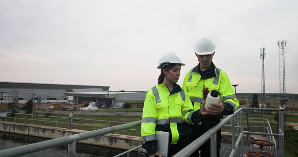 istock Two Industrial or Environment engineer hold sample wastwater discussing on laptop for Sewage treatment 2214614354