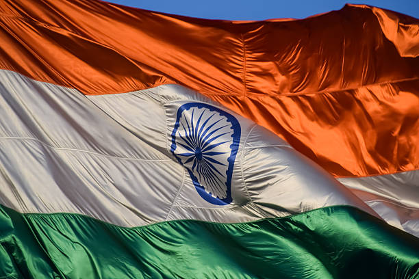 istock India flag flying high at Connaught Place with pride with plain white background, India flag fluttering, Indian Flag on Independence Day and Republic Day of India, tilt up shot, Har Ghar Tiranga 2214614871